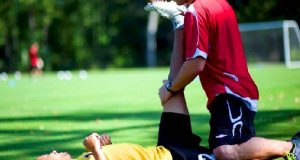 Experiencing Some Relaxing Massage Therapy By a Player During Practice Session in the Ground.