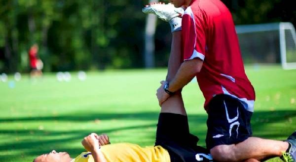 Experiencing Some Relaxing Massage Therapy By a Player During Practice Session in the Ground.